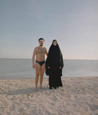 En la playa él en bañador esposa bajo burka.jpg